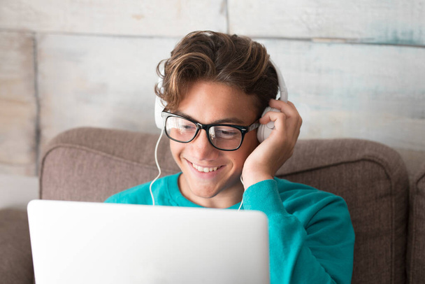 Jong en vrolijk gelukkig tiener in video conferentie chat op laptop computer thuis - lockdown of student met slimme internet technologie - Foto, afbeelding