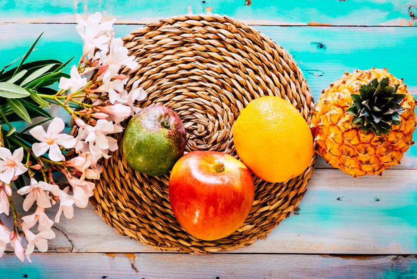 Felett színes élelmiszer kilátás vitaminok friss szezonális gyümölcsök egy kék sárga asztal virágok dekoráció - Fotó, kép
