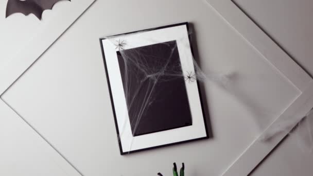 Manos de bruja tocando el marco de fotos en blanco sobre fondo claro. Halloween celebración
 - Metraje, vídeo