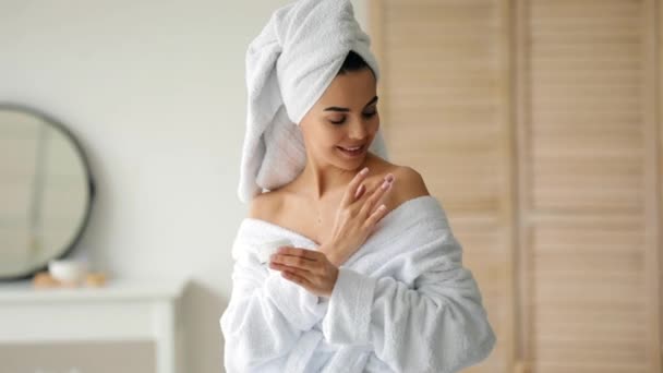 vrouw aanbrengen crème op haar lichaam na het nemen van bad thuis - Video
