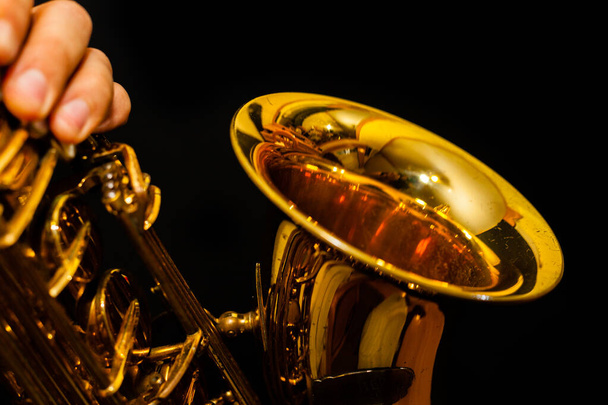 Golden saxophone on black background - Valokuva, kuva