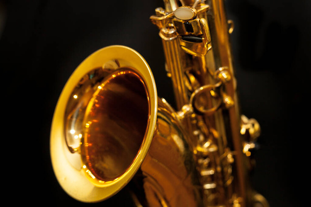 Golden saxophone on black background - Фото, изображение