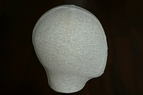 une tête de mannequin en matière grise sur fond brun foncé
 - Photo, image