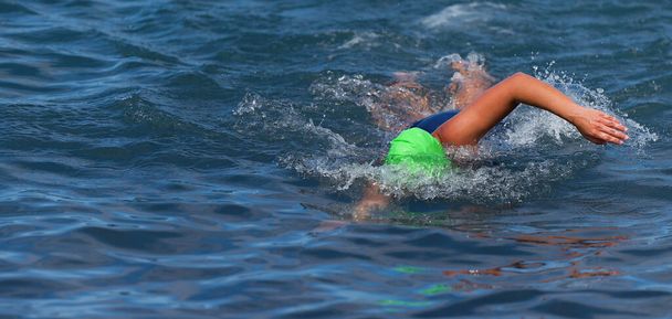 Triatloncu kadın serbest yüzme okyanusta sürünme, kadın triatlon yüzücüsü profesyonel triatlonda yüzme - Fotoğraf, Görsel