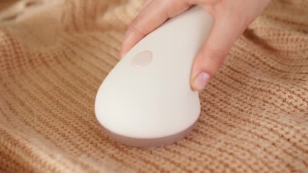 Nő eltávolítása pilling kötött pulóver segítségével szövet borotva, közelkép - Felvétel, videó