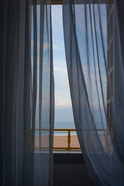 Gezinti güvertesindeki bir evin penceresinden Nazare sahili manzarası - Fotoğraf, Görsel
