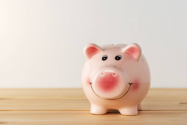 Piggy bank on a wooden table. Saving money concept. - Zdjęcie, obraz