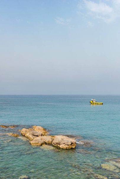 Yellow boat on the sea surface on a sky background.  - Foto, imagen
