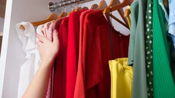 Nainen valitsemalla vaatteita vaatekaappi kotona, lähikuva
 - Materiaali, video
