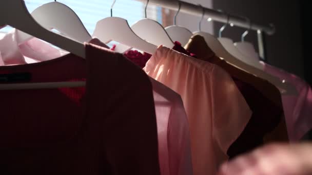 Nainen valitsemalla vaatteita vaatekaappi kotona, lähikuva
 - Materiaali, video