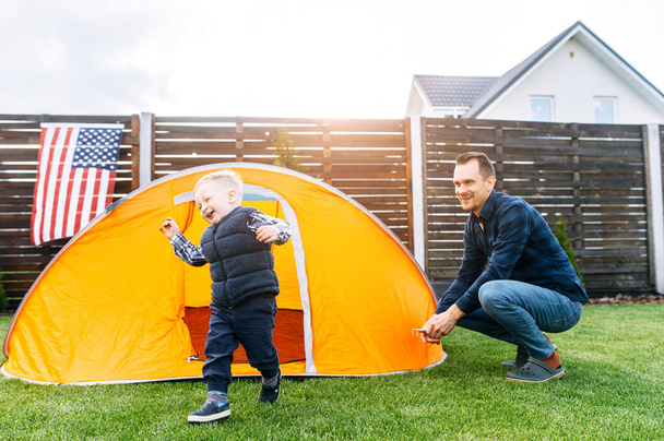Father and toddler son camped in the backyard - 写真・画像