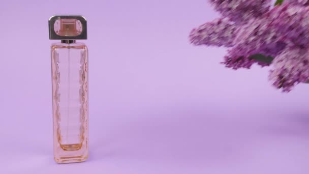 Bottle of lilac perfume on color background - Footage, Video