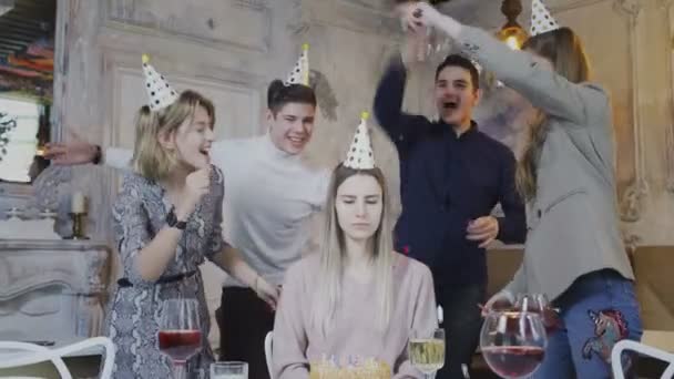 Surullinen syntymäpäivä tyttö istuu pöydässä, kun ystävät onnittelevat häntä - Materiaali, video