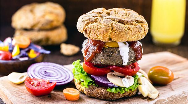 vegan snack, meatless hamburger, vegetarian food based on plants and proteins, with organic ketchup and white herbal sauce. Healthy food. - Photo, Image