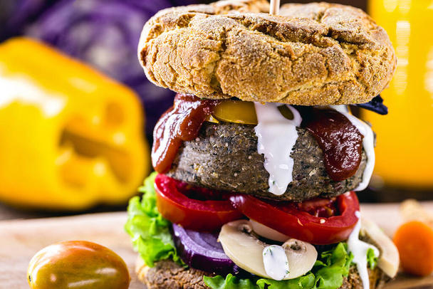 vegán snack, húsmentes hamburger, növényeken és fehérjéken alapuló vegetáriánus étel, organikus ketchuppal és fehér gyógynövénymártással. Egészséges élelmiszer. - Fotó, kép