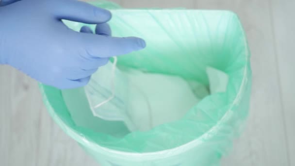 Arzt wirft in Zeitlupe Einmalhandschuhe und Maske weg, die nach Beendigung der Schicht im Krankenhaus gebraucht und verunreinigt wurden - Filmmaterial, Video