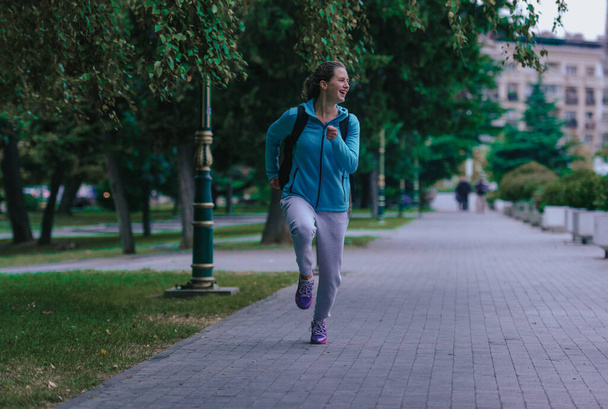 Mladý atletický dívka na sobě sportovní oblečení během venkovní běh cvičení - Fotografie, Obrázek