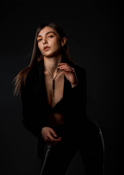 Studio body shot of a fashion female model posing in modern latex clothing - 写真・画像