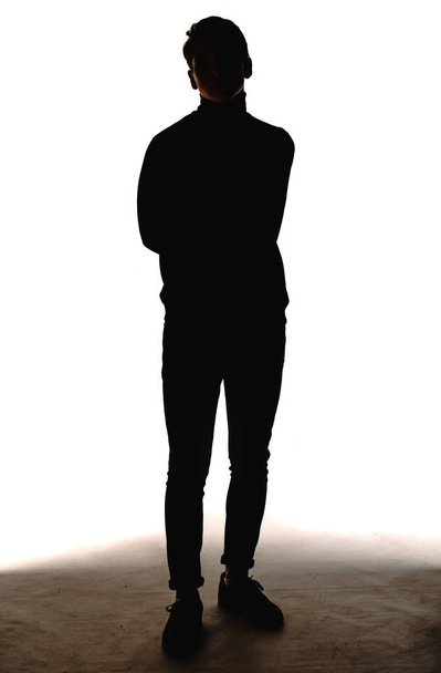 Stüdyo moda portresi. Beyaz arka planda, kot pantolon ve uzun kollu gömlek giyen yakışıklı bir adam. - Fotoğraf, Görsel