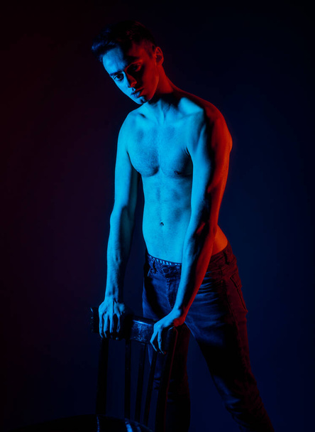 Portrait of an attractive shirtless guy in blue jeans posing - Фото, изображение