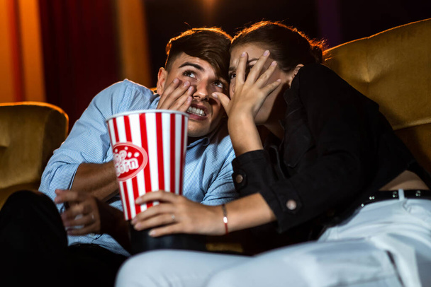 Um casal de amantes assistindo filme choque e olhos perto no cinema de cinema. - Foto, Imagem