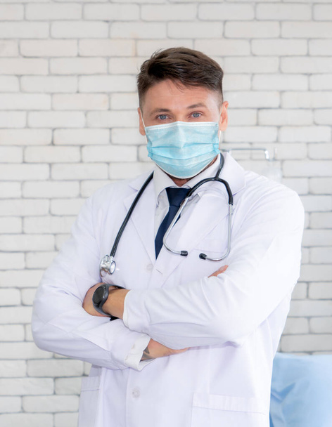 Γιατρός φορούν μάσκα προσώπου στο νοσοκομείο προστασία από την ασθένεια coronavirus ή COVID-19. Ιατρικό προσωπικό είναι άτομα υψηλού κινδύνου για να λάβετε λοίμωξη από την ασθένεια coronavirus ή COVID-19. - Φωτογραφία, εικόνα