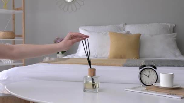 Frau mit Schilfrohr-Diffusor auf Nachttisch im Zimmer - Filmmaterial, Video