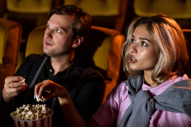 Valkoihoinen rakastaja nauttii elokuvan katselusta ja popcornin syömisestä yhdessä elokuvassa - Valokuva, kuva