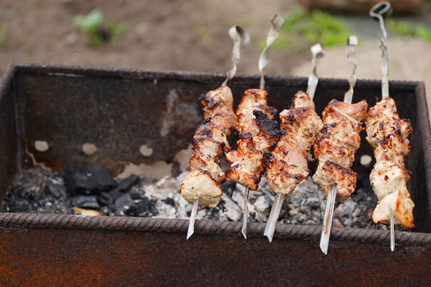 Close up of toasted shashlik on skewers. Succulent barbecue roasting on chargrill. - Zdjęcie, obraz