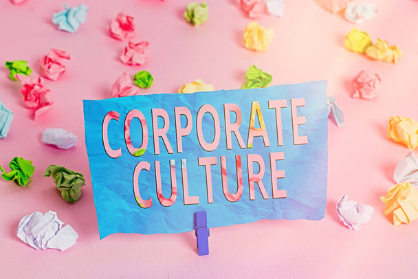 Word writing text Corporate Culture. Geschäftskonzept für allgegenwärtige Werte und Einstellungen, die ein Unternehmen charakterisieren Farbige zerknitterte Papiere leere Erinnerung rosa Fußbodenhintergrund Wäscheklammer. - Foto, Bild