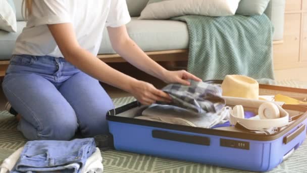 Jovem mulher embalando bagagem em casa
 - Filmagem, Vídeo