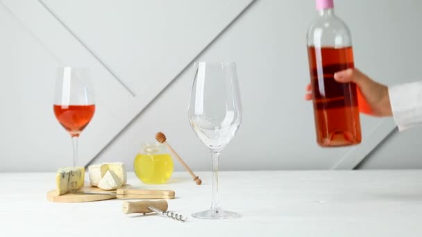 La mujer que vierte el vino sabroso de la botella en el vaso sobre la mesa
 - Metraje, vídeo