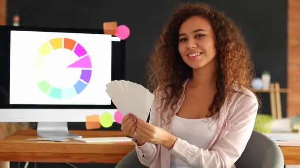 Designer afro-americano feliz com paletas de cores no escritório
 - Filmagem, Vídeo