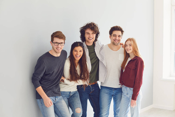 Group of young people in casual clothes smiling while gray background. - Zdjęcie, obraz