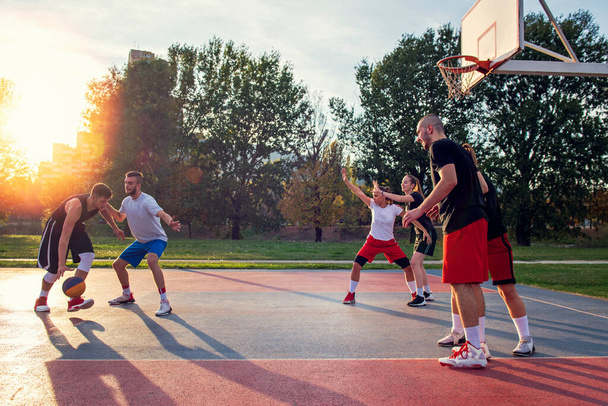 Group Of Young Friends Playing Basketball Match - 写真・画像