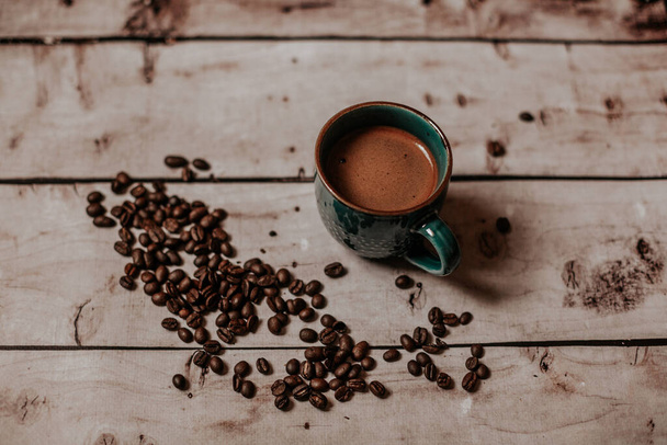 чашка з кавою з кавовими зернами на дерев'яному столі
 - Фото, зображення