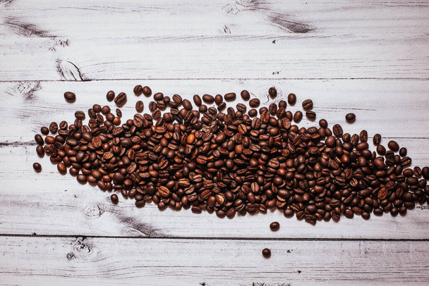 sprinkled coffee beans on a wooden table - Photo, Image