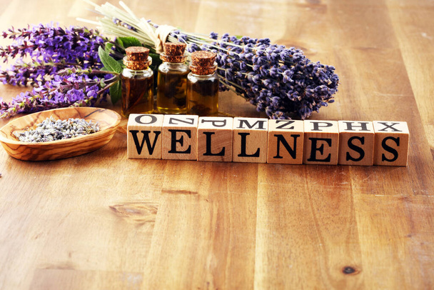 Lavendelkräuteröl und Lavendelblüten. Flasche Lavendel-Massageöl für Aromatherapie und Wellness-Buchstaben aus Holz - Foto, Bild