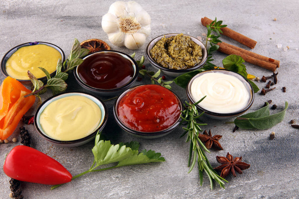 Ассортимент соусов. Набор различных соусов в мисках с кетчупом, майонезом, песто и горчицей
 - Фото, изображение