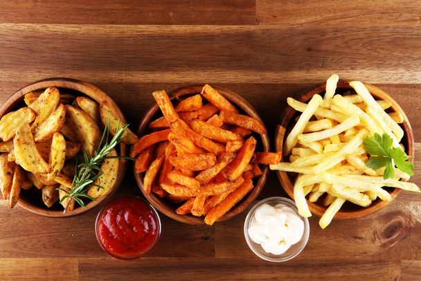 Variety of potatoes with fries. potato wedges, french fries, sweet potato for lunch on background - Photo, Image