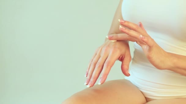 La mujer aplica crema hidratante en sus manos. Cuidado de la piel y concepto anti envejecimiento
. - Metraje, vídeo