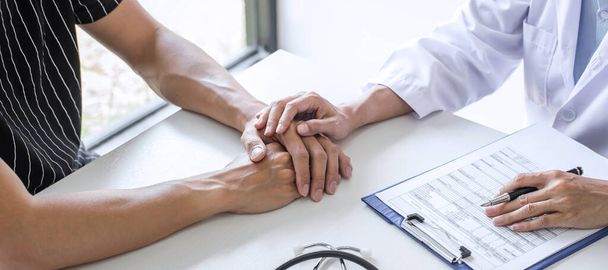 Doctor touching patient hand for encouragement and empathy in the hospital, cheering and support patient, Bad news, medical examination, trust and ethics. - Foto, Imagen