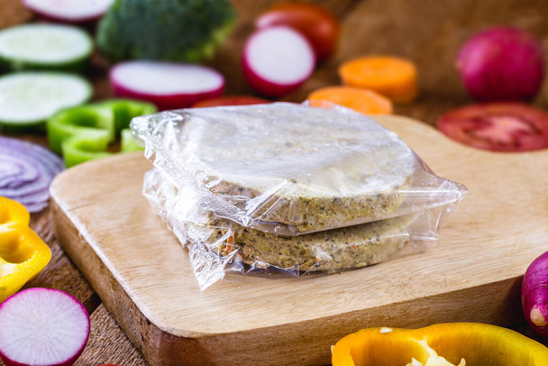 closeup of packaged and frozen vegetarian hamburger. Home made with vegetables, chickpeas, soy and proteins. Vegetarian life and vegetarian meal concept. - Photo, Image