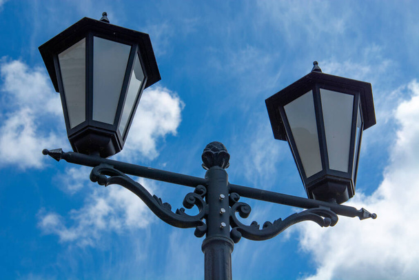 уличный фонарь против голубого неба и белого облака
 - Фото, изображение