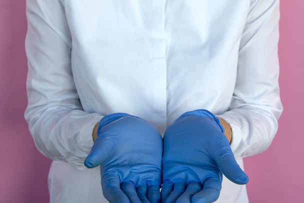 женщина-врач в латексных перчатках показывает руки
 - Фото, изображение