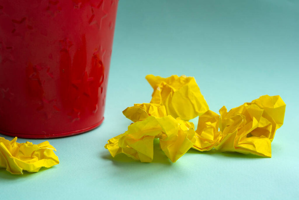 red metal bucket with crumpled yellow paper.Creativity crisis concept - Photo, Image