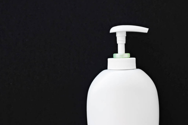 Blank label cosmetic container bottle as product mockup on black background - Valokuva, kuva