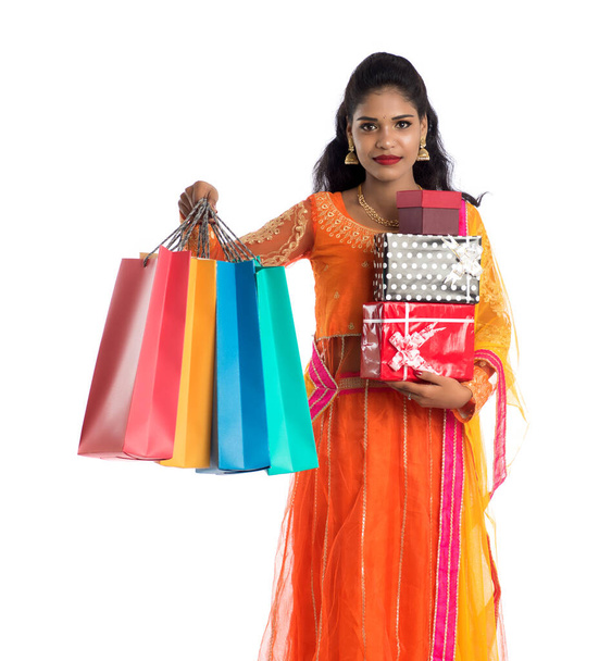 Beautiful woman carrying many shopping bags and gift Box on a white background. - Photo, image