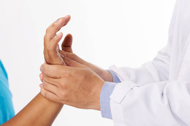 De handen van de arts masseren de hand van de patiënt als gevolg van letsel.Fysiotherapie concept. - Foto, afbeelding