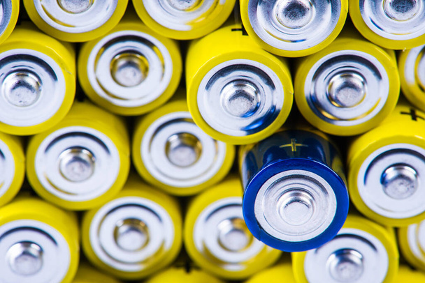 Pile of alkaline batteries size aaa with selection focus on single one - 写真・画像